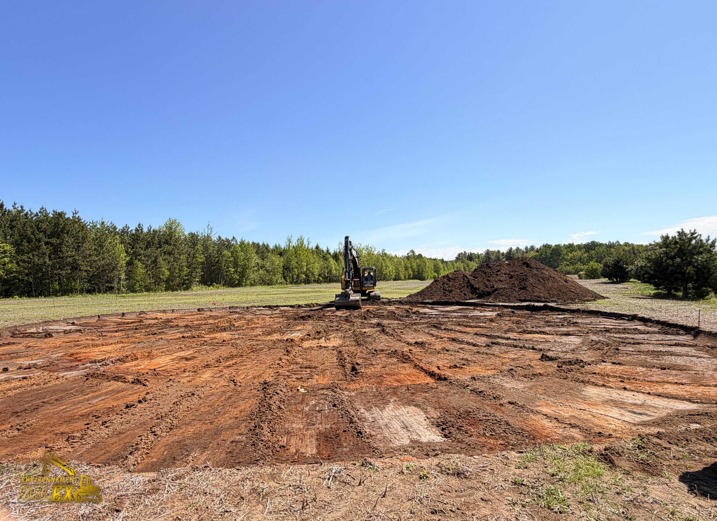 Terrain excavé avec pelle mécanique et amas de terre